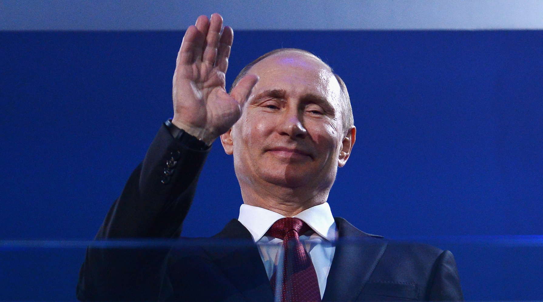 Vladimir Putin waves at spectators during the Sochi Olympic Games